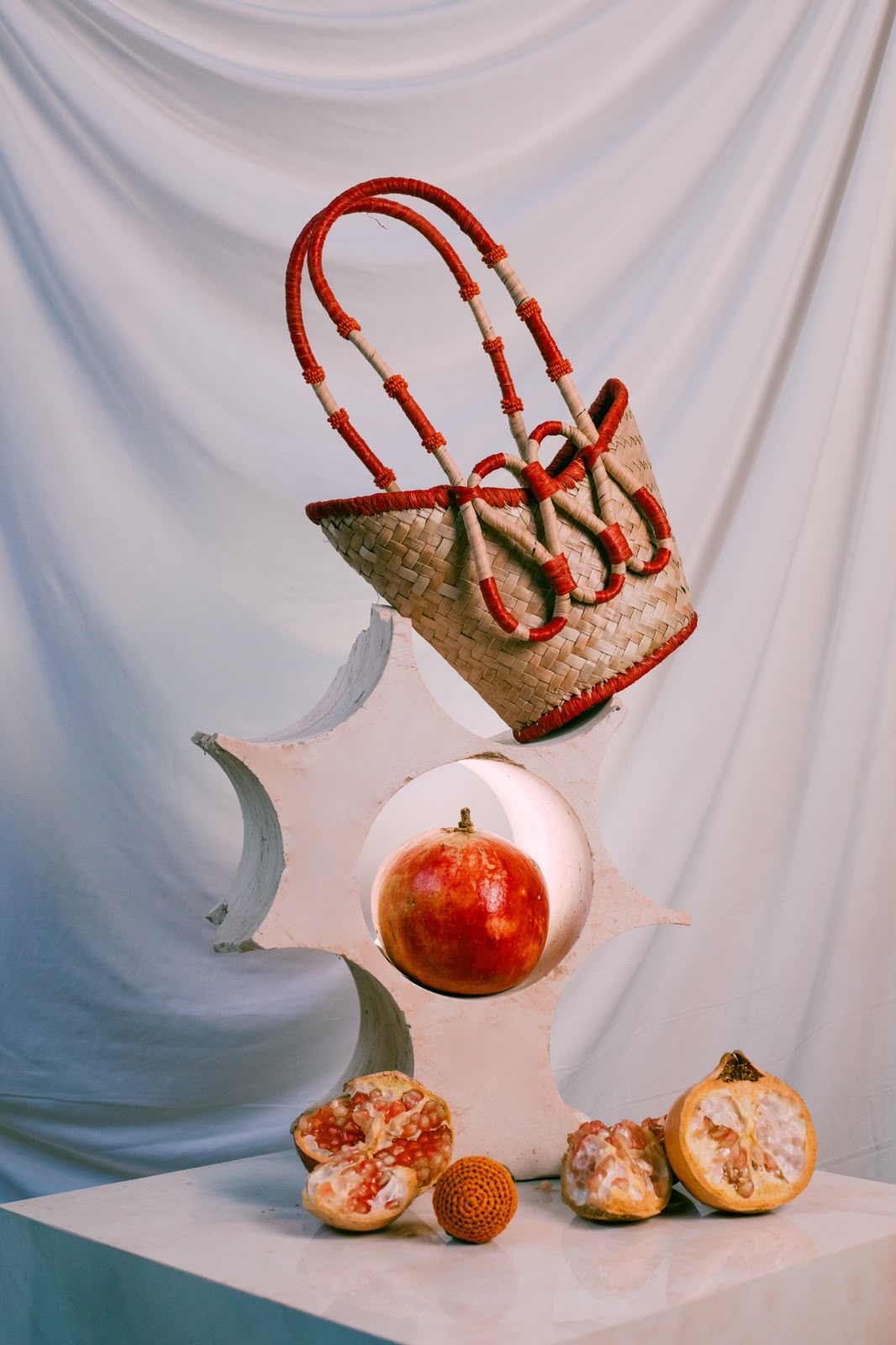 La Sculpture Hot Red — panier YZA tressé main posé avec des grenades à Marrakech