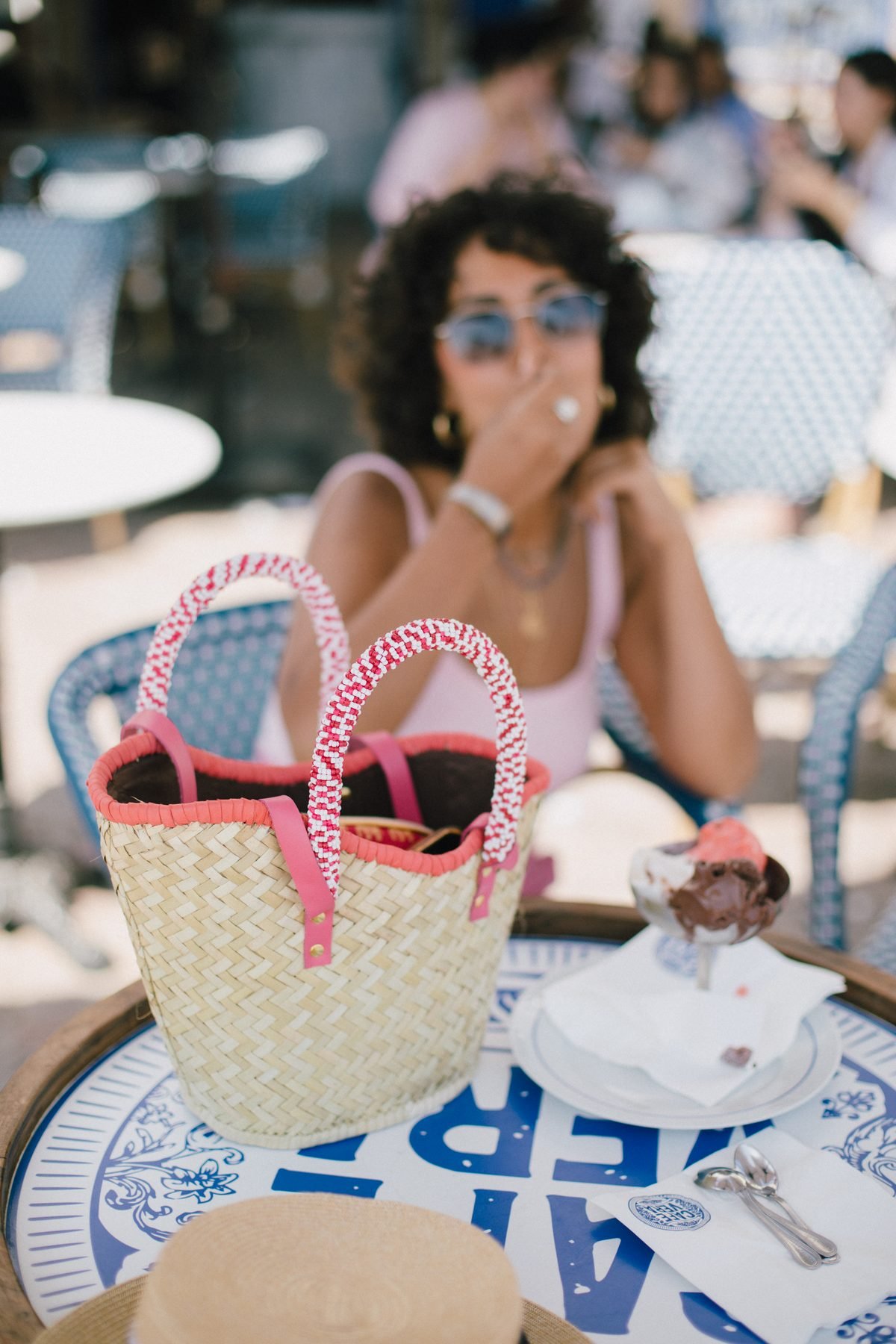 Panier La Nouvelle Vague à ganse rose sur une terrasse de café